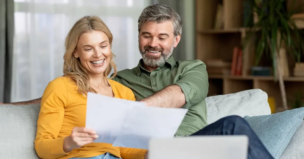 A happy couple excitedly reviewing real estate investment opportunities in Houston for 2025